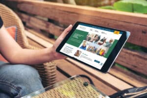Woman holding tablet with NWMF website in view