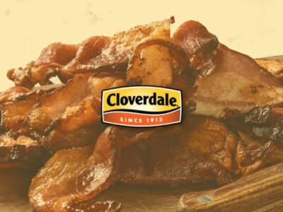 Pile of cooked bacon on cutting board with Cloverdale logo