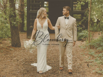 Bride and groom walking on a path with Bloomberry Floral Design logo