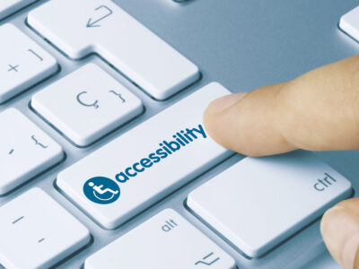 Finger clicking on accessibility button on computer keyboard