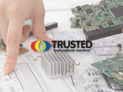 Hand pointing at documents for micro chips with Trusted Semiconductor Solutions logo