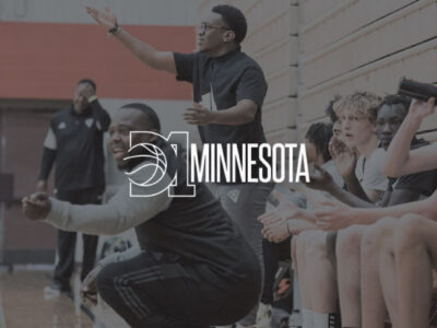 Coaches on sideline giving directions for basketball with D1 Minnesota logo