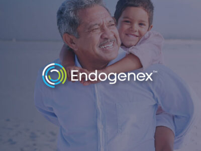 Older man carrying small child on back walking on beach with Endogenex logo