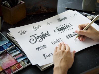 Artist using a pen drawing fonts for logos on paper