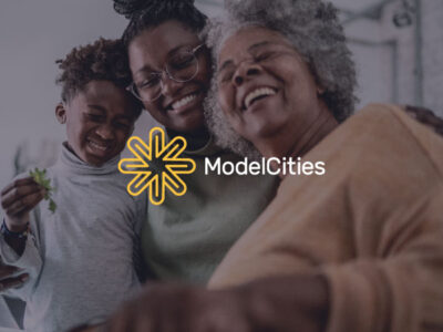 Happy family cooking at home with Model Cities logo