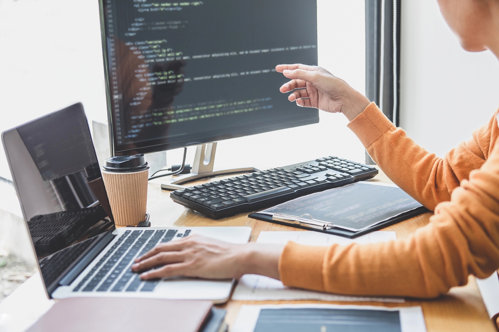 Professional programmer working at developing a website with code on monitor