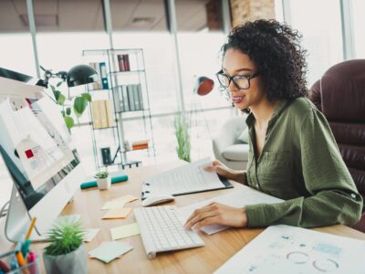 Young woman working in her office analyzing data and reports