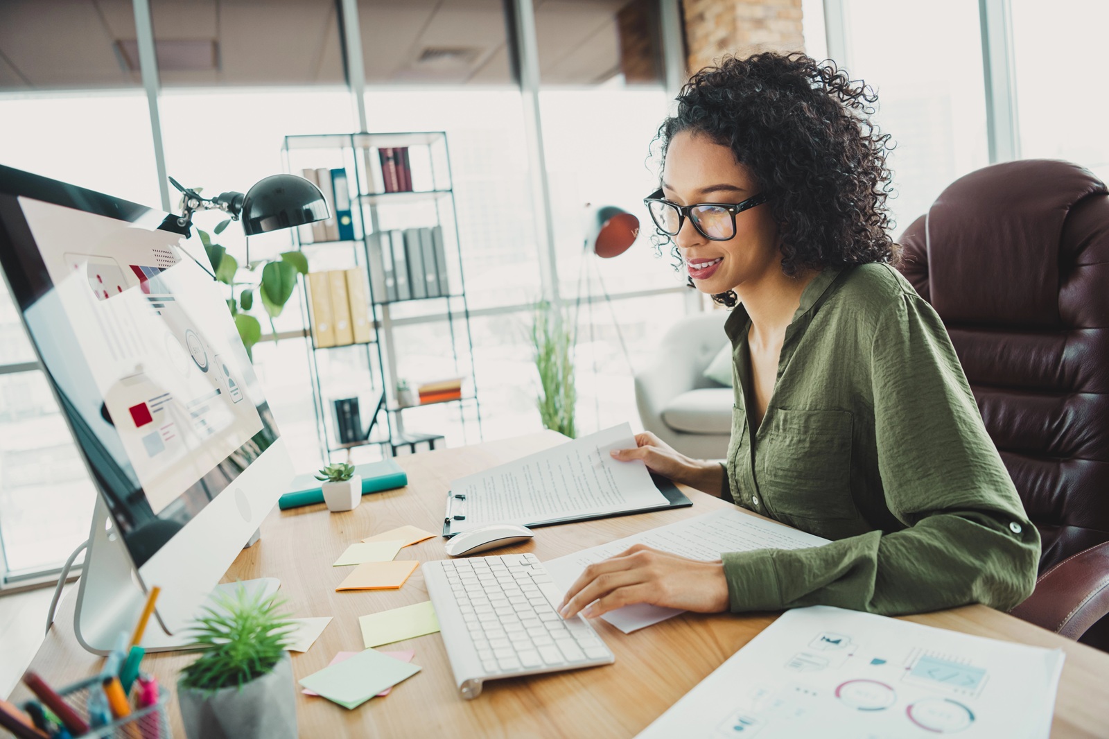 Young woman working in her office analyzing data and reports