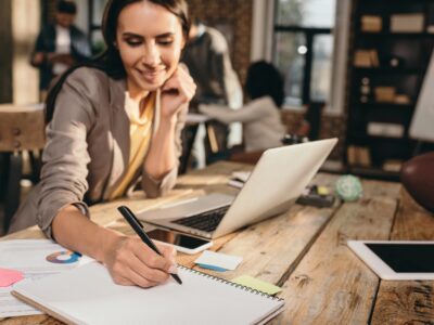 business woman sitting at desk with laptop and working on project