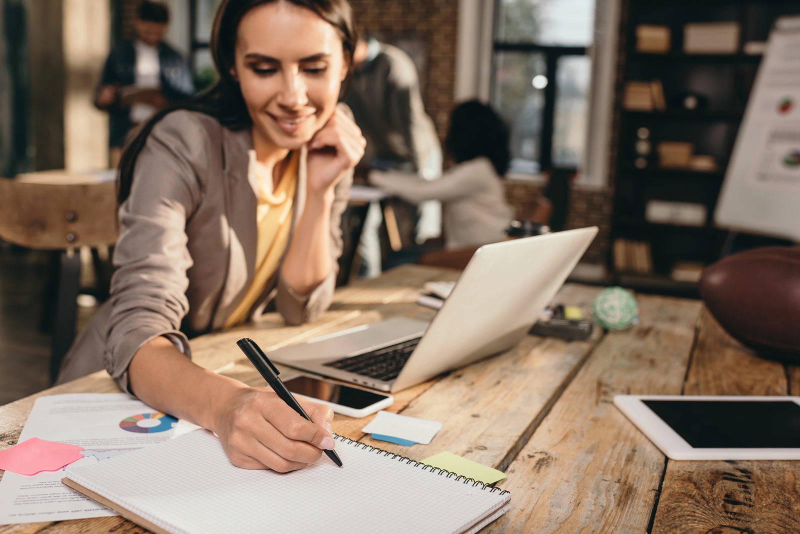 business woman sitting at desk with laptop and working on project
