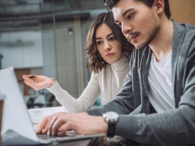 young woman and a man collaborate on a project in a modern office setting