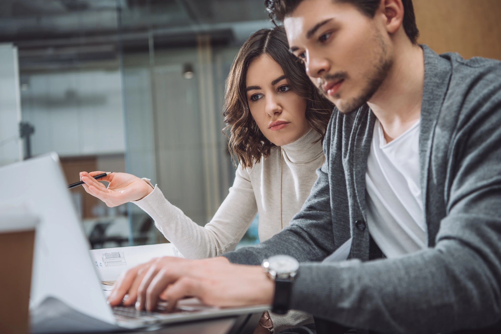 young woman and a man collaborate on a project in a modern office setting