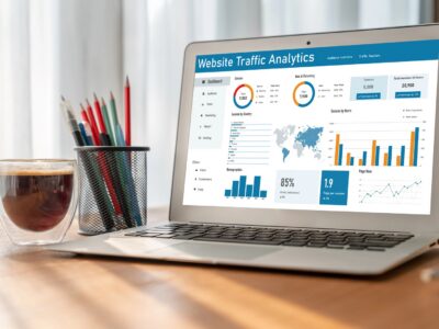 Laptop computer on desk with website traffic graphs and location information